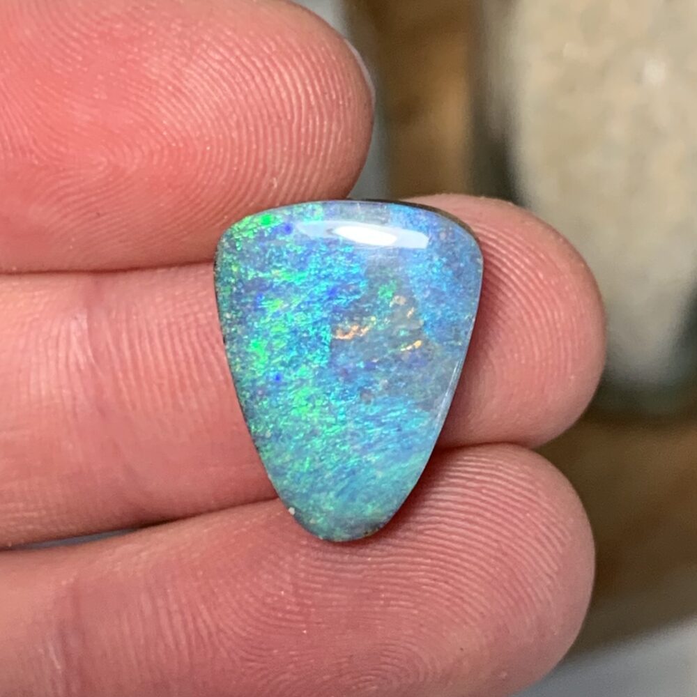Wappenförmiger, türkis und blau leuchtender Opal